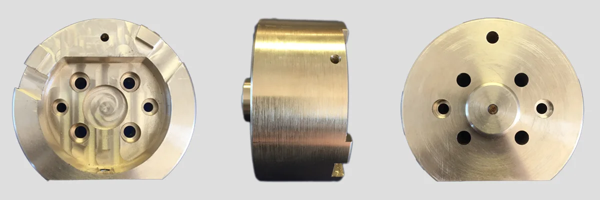 Three views of a machined bronze rotor component