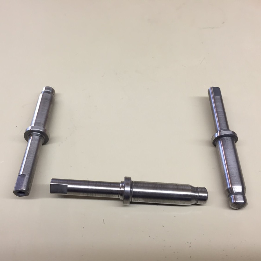 Three turned shafts with shoulders, keyways, and machined flats